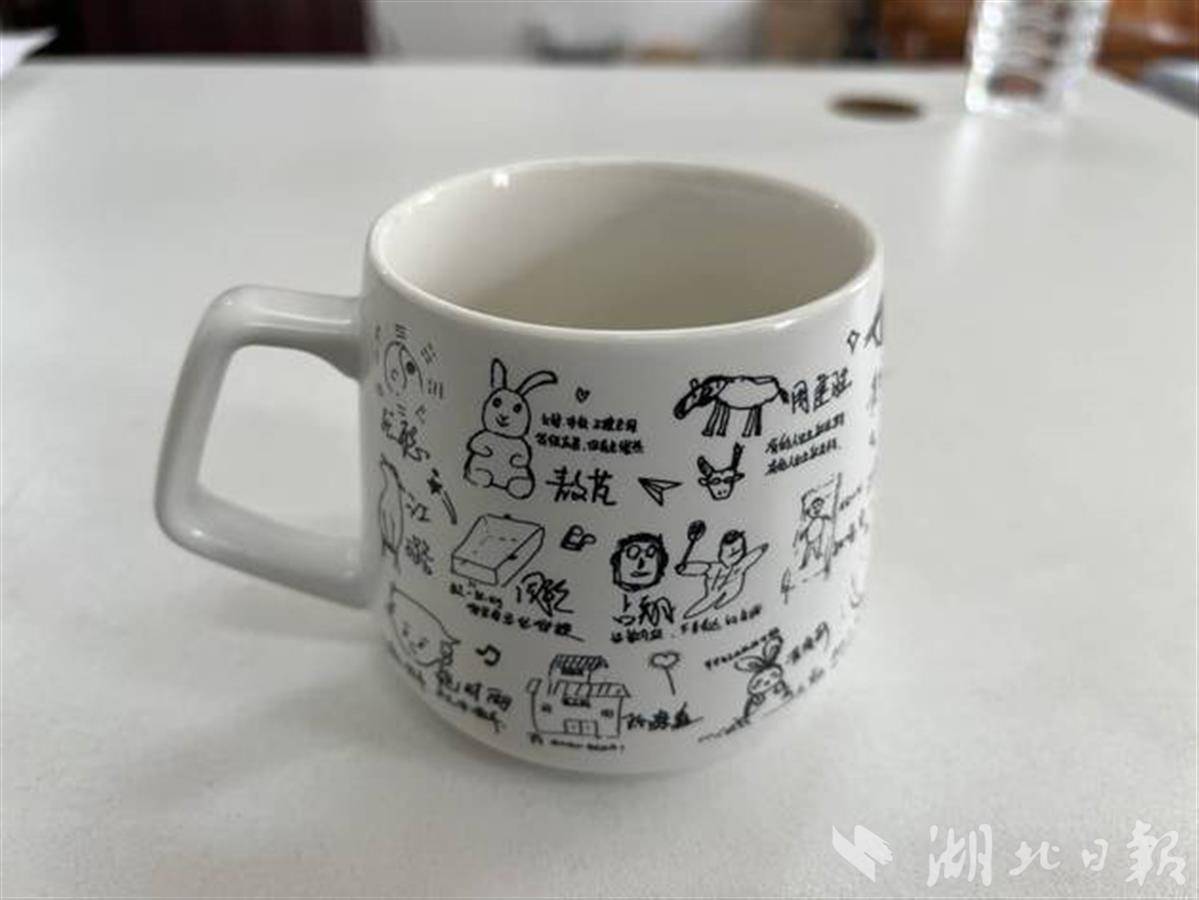 杨帆用学生签名涂鸦制作的水杯.jpg 杨帆用学生签名涂鸦制作的水杯